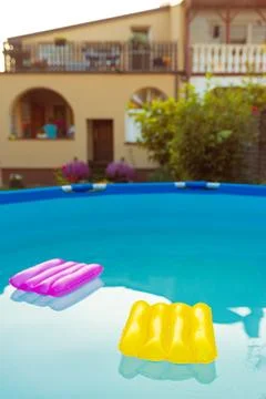 Two inflatable pillows lie on the surface of the water in the pool Stock Photos
