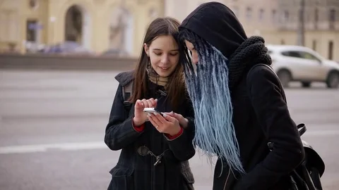 Two informal girl with large dreadlocks of one is using modern smartphone 動画素材 83323807