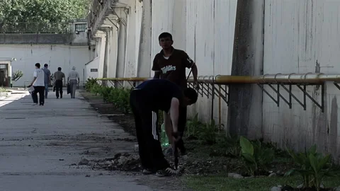 Two Inmates Doing Some Maintenance Work at the Yard of a Prison in Argentina.   Stock Footage 201643432