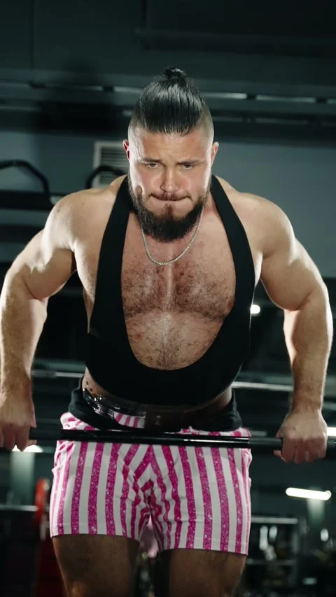 Two intense frames of a determined bodybuilder in a gym executing a heavy lift Stock Footage 329557500