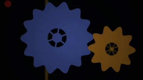 Two interlocking gears, one blue and one orange, against a black background. Stock Footage 334542732