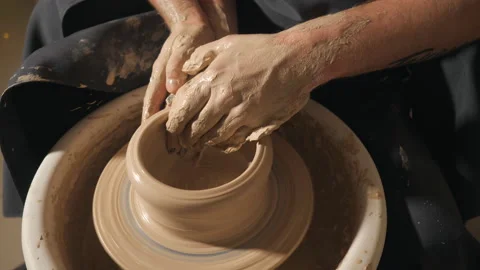Two intertwined hands form a pot of clay on a potter's wheel. Stock Footage 102248636