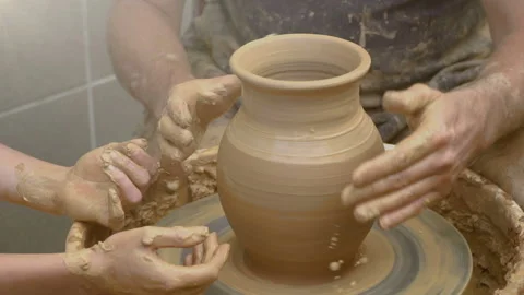 Two intertwined hands form a pot of clay on a potter's wheel. Stock Footage 106118210