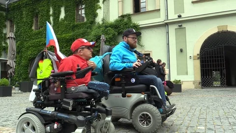 Two invalid men on an electric modern wheelchair, the authentic situation Video stock 89628937