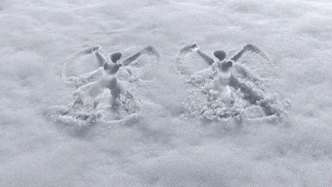 Two invisible men making snow angels design on a fresh snow Stock Footage 101439090