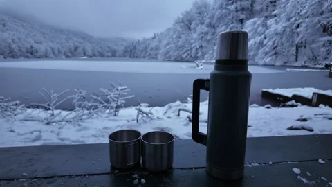 Two iron camping cups standing next to a thermos. Stock Footage 312871060