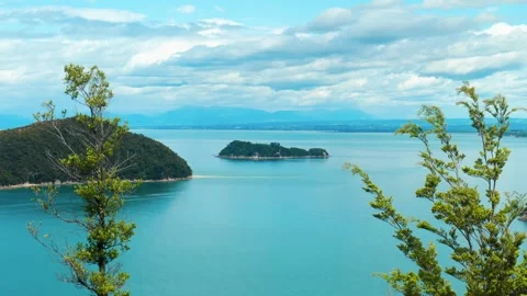 Two island through trees in Abel Tasman National Park Видео 260370200