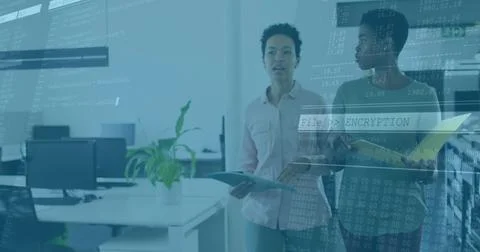 Two IT colleagues analyzing encryption code in modern office, with laptop and Foto stock