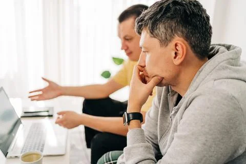 Two IT freelancer men typing in laptop working from home office. Two programmers Stock Photos