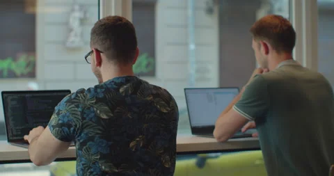 Two IT programmers are working on computer in a modern office room. Web Stock Footage 137173629