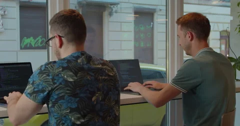 Two IT programmers are working on computer in a modern office room. Web Stock Footage 137175995