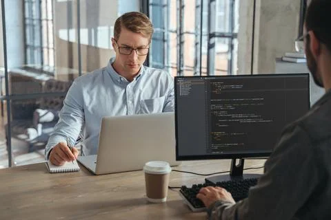 Two IT specialists co-working at office, working on new product Stockfoto's