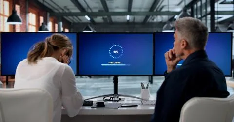 Two IT Specialists Working Together To Update Slow Computer Systems. Stock Photos