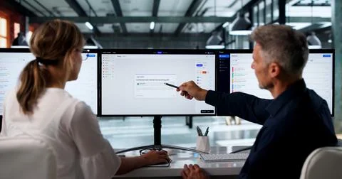 Two IT Support Specialists Work Together At Computer Desk Solving Service Tic 库存照片