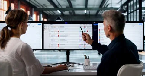 Two IT Support Specialists Work Together Using Software On Computer Screens. Fotos Stock