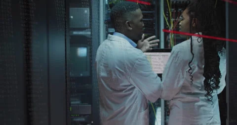 Two IT technicians inspecting server racks in data center, with floating code Stock Footage 309068706