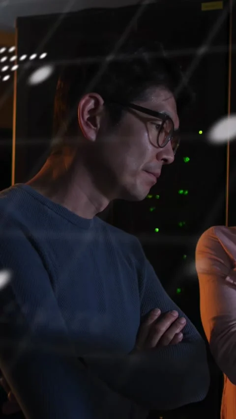 Two IT techs standing arms crossed watching map shifting and scrolling code and Stock Footage 332734533