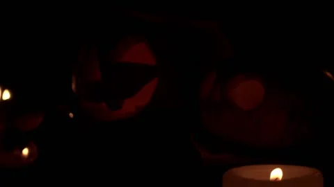 Two Jack lanterns with blinking eyes from the candle flame closeup Stock Footage