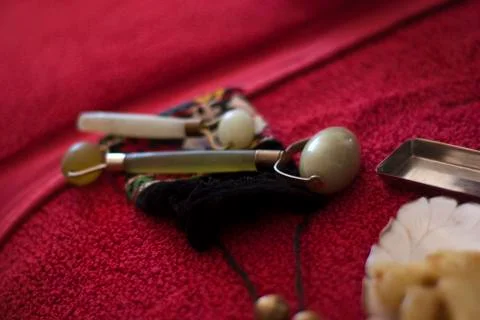 Two jade rollers on an embroidered pouch. Stock Photos