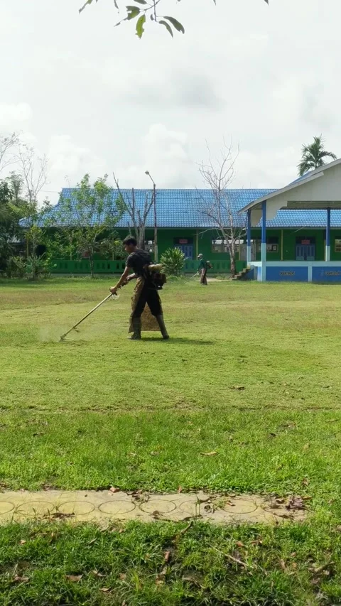 Two janitors are cutting grass in the yard. Stock Footage 306472888