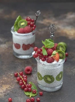 Two jars with chia seeds pudding with raspberries, red currants, berry kiwi and Stock Photos