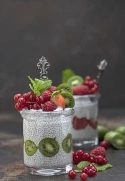 Two jars with chia seeds pudding with raspberries, red currants, berry kiwi and Stock Photos