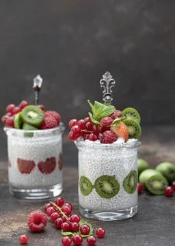 Two jars with chia seeds pudding with raspberries, red currants, berry kiwi and Stock Photos