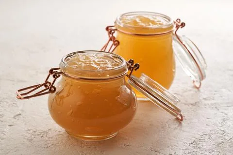 Two jars of cooled down congealed beef bone broth on a bright background Stock Photos