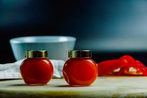 Two jars of red pepper jelly on table Stock Photos