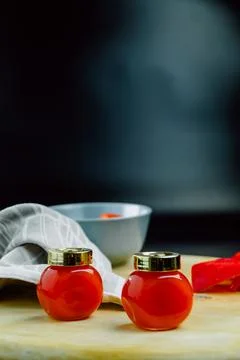 Two jars of red pepper jelly on table Stock Photos