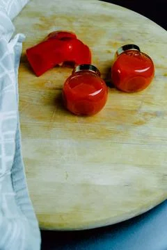 Two jars of red pepper jelly on table Stock Photos