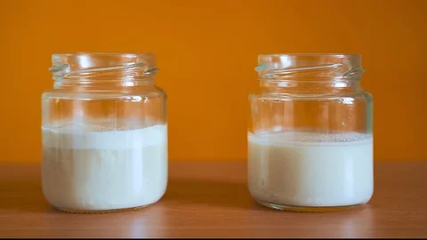 Two jars of yeast are fermented in turn. To the left is ordinary yeast. Dry on Stock Footage 129355873