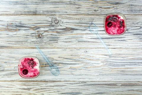 Two jars of yogurt stands on the aged boards Stock Photos
