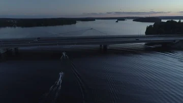 Two Jet Skis Chasing the Boat Under the Beautiful Bridge on a Dead Calm lake Stock Footage 85977340