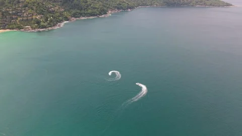 Two jet skis create waves while maneuvering in clear blue ocean water Stock Footage 336926596