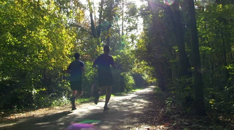 Two joggers running in a forest Stock Footage 32258389