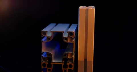 Two joined aluminum profiles turn slowly under blue and orange light Vídeo Stock 331443594