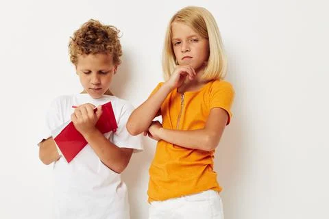 Two joyful children draw in the notebook childhood entertainment color Stock Photos
