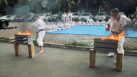 Two karate men in kimonos break the flaming stone Stock Footage 119854573