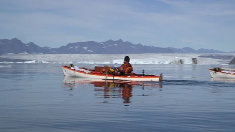 Two kayakers in the Arctic Ocean front of Greenlandic mountains Stock Footage 103504978