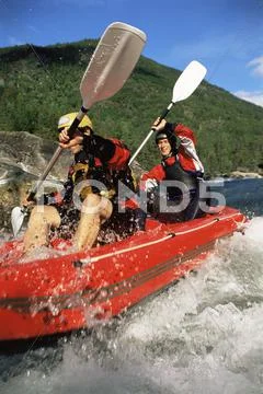 Two kayakers going into in rapids and smiling (selective focus) Stock Photos