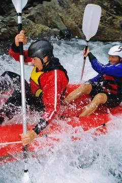 Two kayakers rowing in rapids and smiling (selective focus) Stock Photos