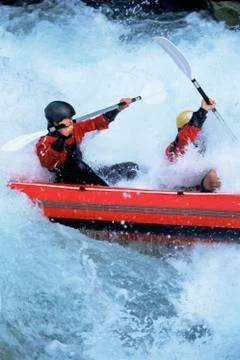 Two kayakers rowing in rapids Stock Photos