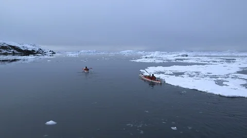 Two kayakers sailing in the middle of the ice floe, Greenland Video stock 104183729