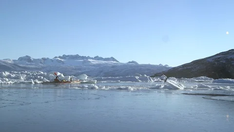Two kayakers sailing in the middle of the ice floe, Greenland Video stock 104185750