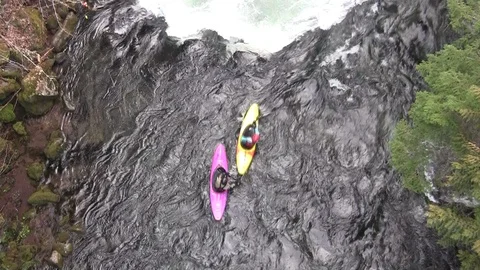 Two kayaks away from camera- down whitewater river Stock Footage 125410974