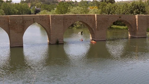 Two Kayak‘s paddle under historic bridge in La Rioja, Spain – wide shot Stock Footage 97987558