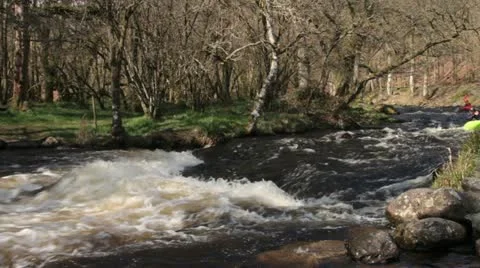 Two kayaks paddling down Welsh stream Stock Footage 10897027