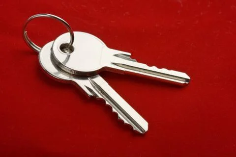 Two keys on a ring over red background Stock Photos