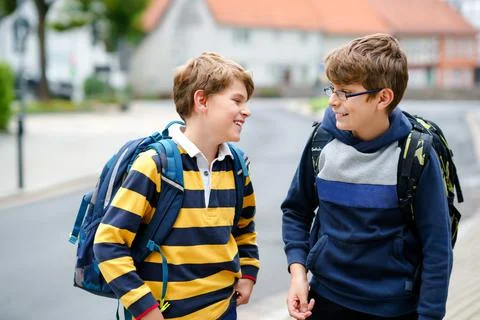 Two kid boys with backpack or satchel. Schoolkids on the way to school. Healthy Stock Photos